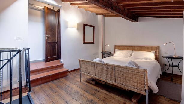 Ein Schlafzimmer mit Holzboden, einem Bett, einem Nachttisch und einem kleinen Tisch.