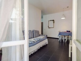 Apartamento conforto, vista para o jardim | Sala de estar | TV de tela plana