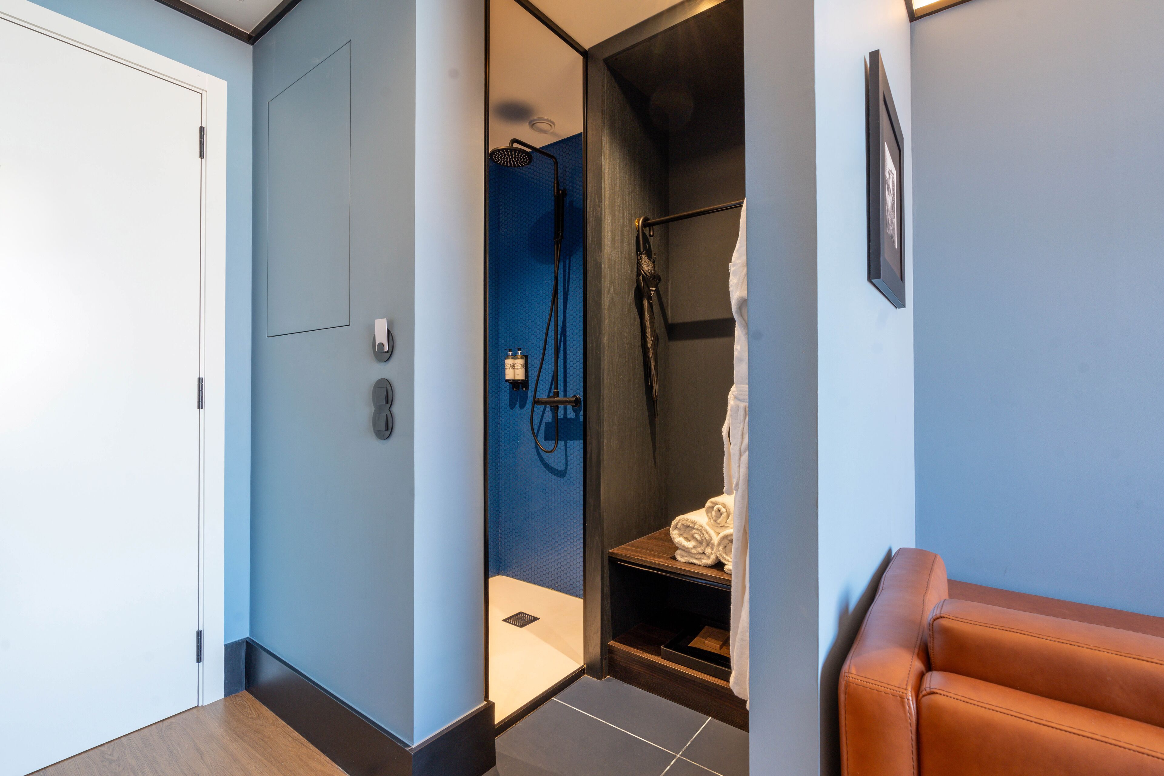 Une salle de bain moderne avec une douche, un porte-serviettes et un tableau encadré au mur.