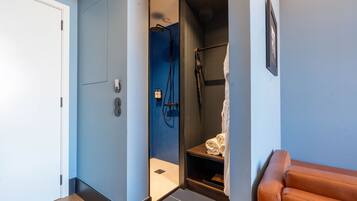 A modern bathroom with a shower, a towel rack, and a framed picture on the wall.