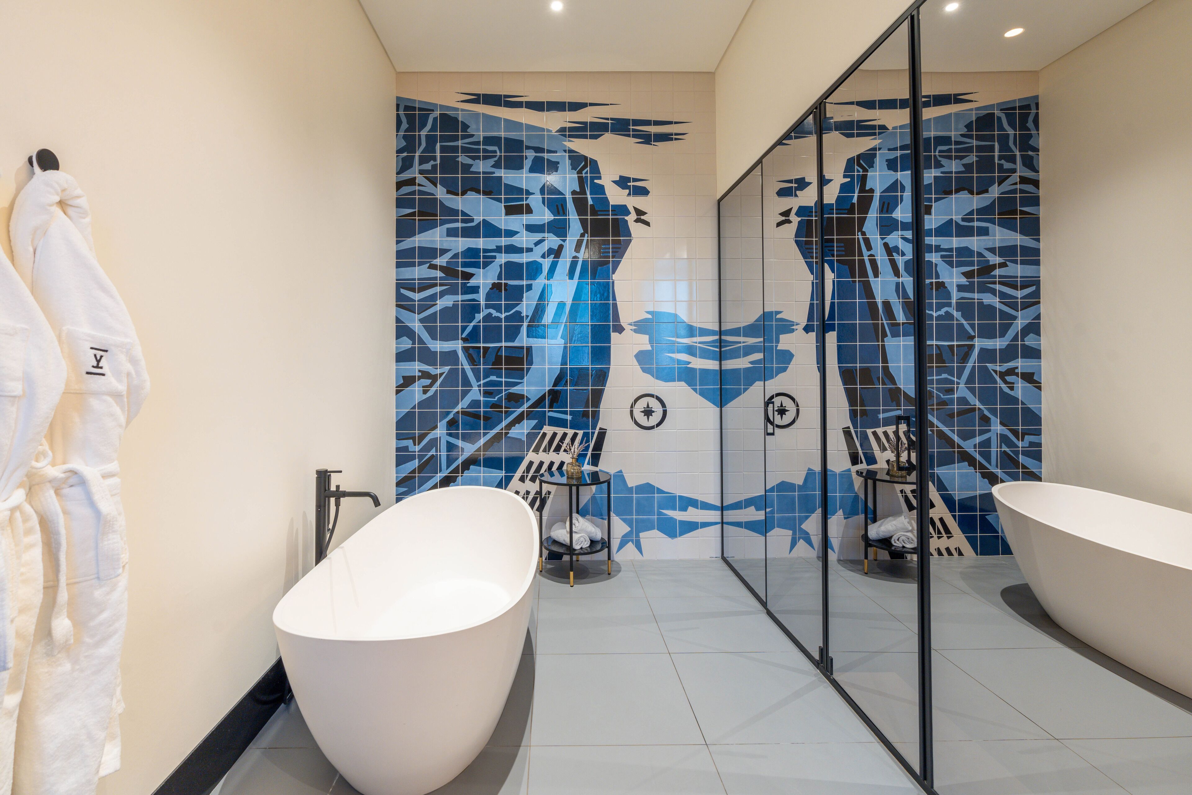 Un baño moderno con una bañera grande, una zona de ducha independiente y un tocador con recinto de vidrio.