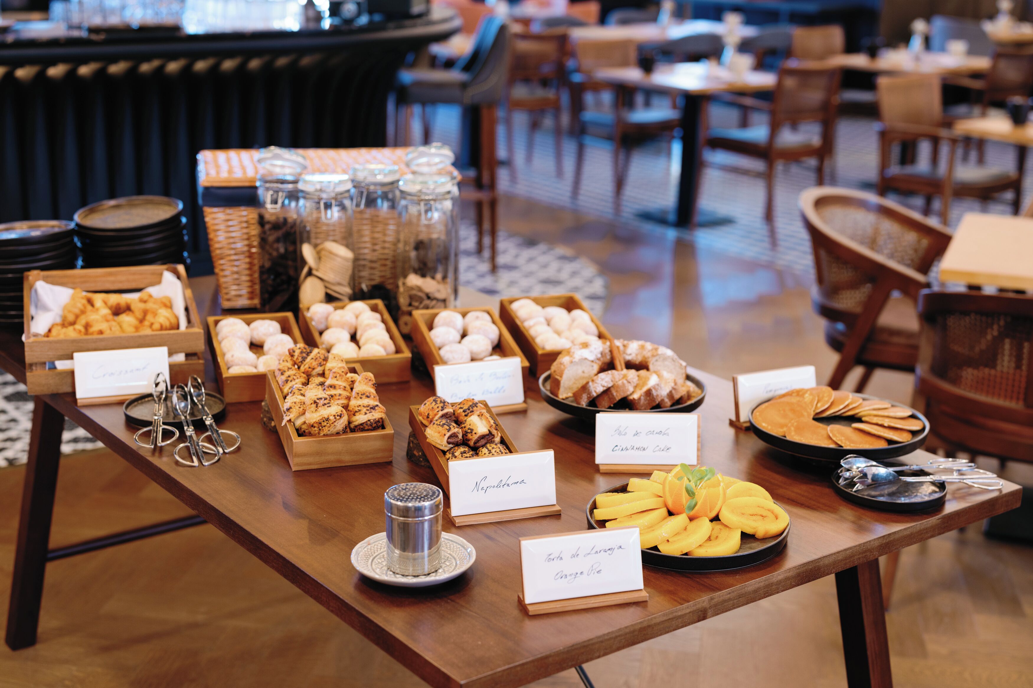 A buffet table with various food items and labels.