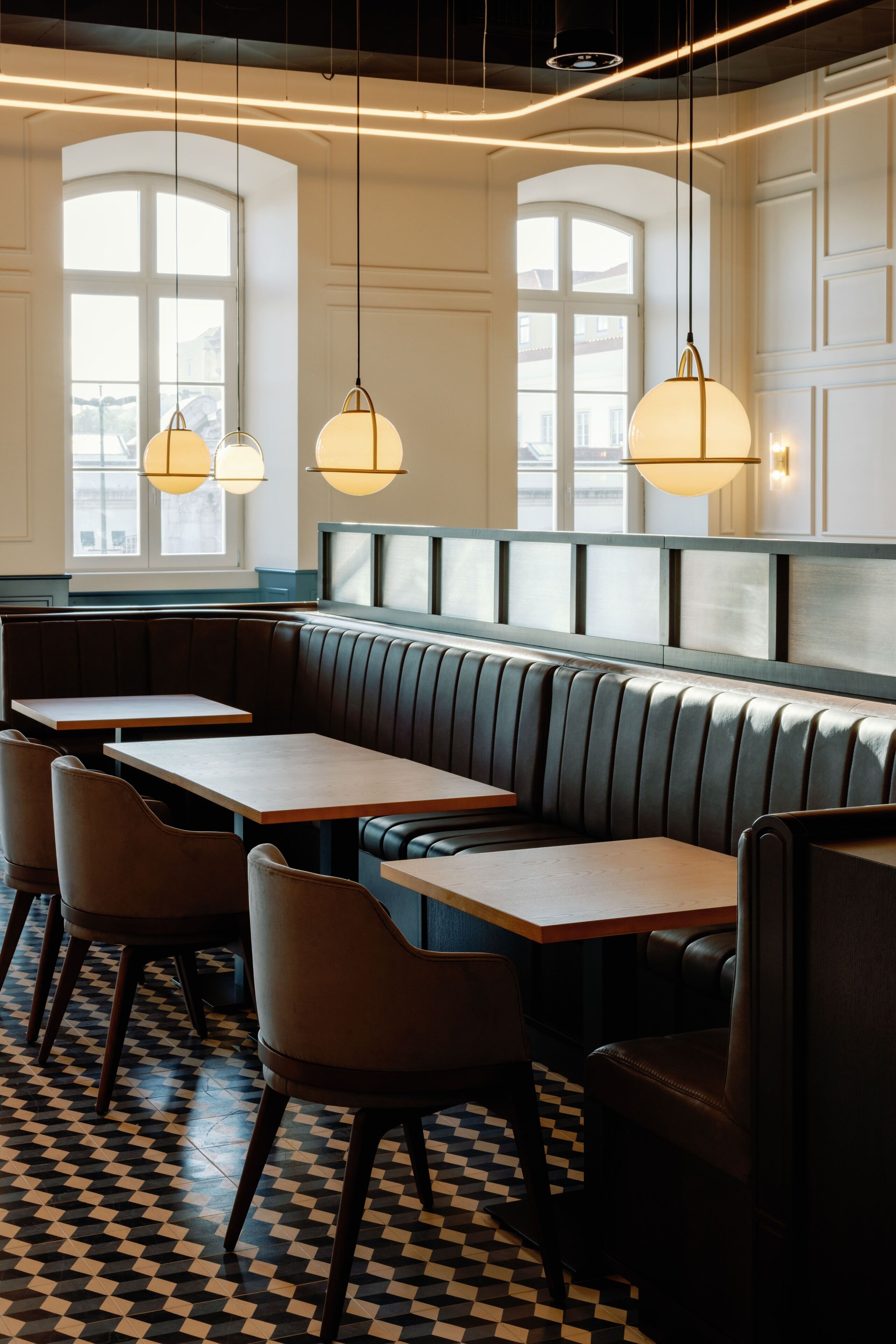 A restaurant interior with a checkered floor, booth seating, and pendant lighting.