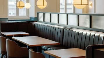 A restaurant interior with a checkered floor, booth seating, and pendant lighting.