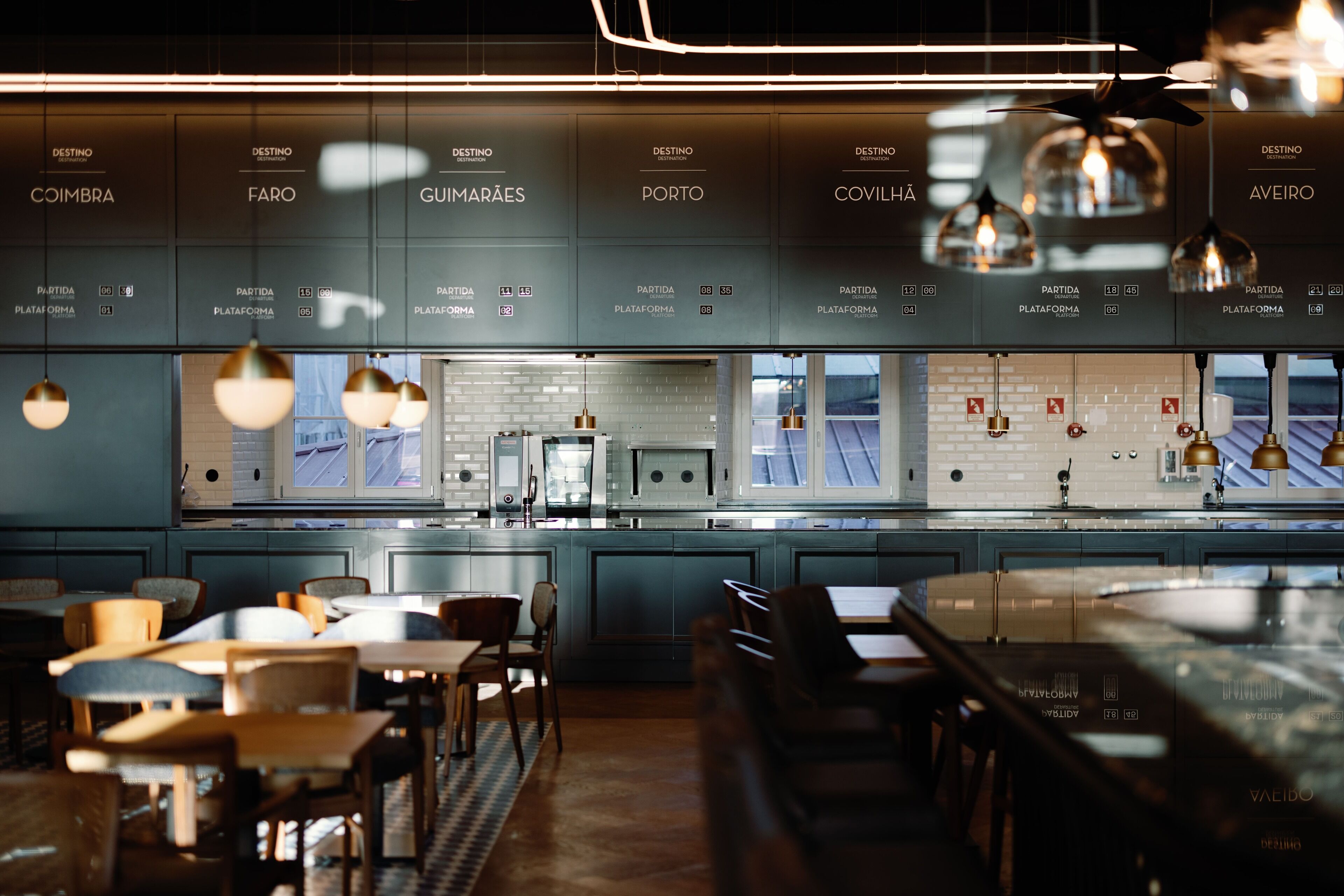 Un restaurant moderne doté d’un bar, de tables et offrant une vue sur la ville.
