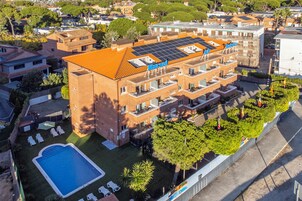 Un edificio de varios pisos con jardín en la azotea y paneles solares.