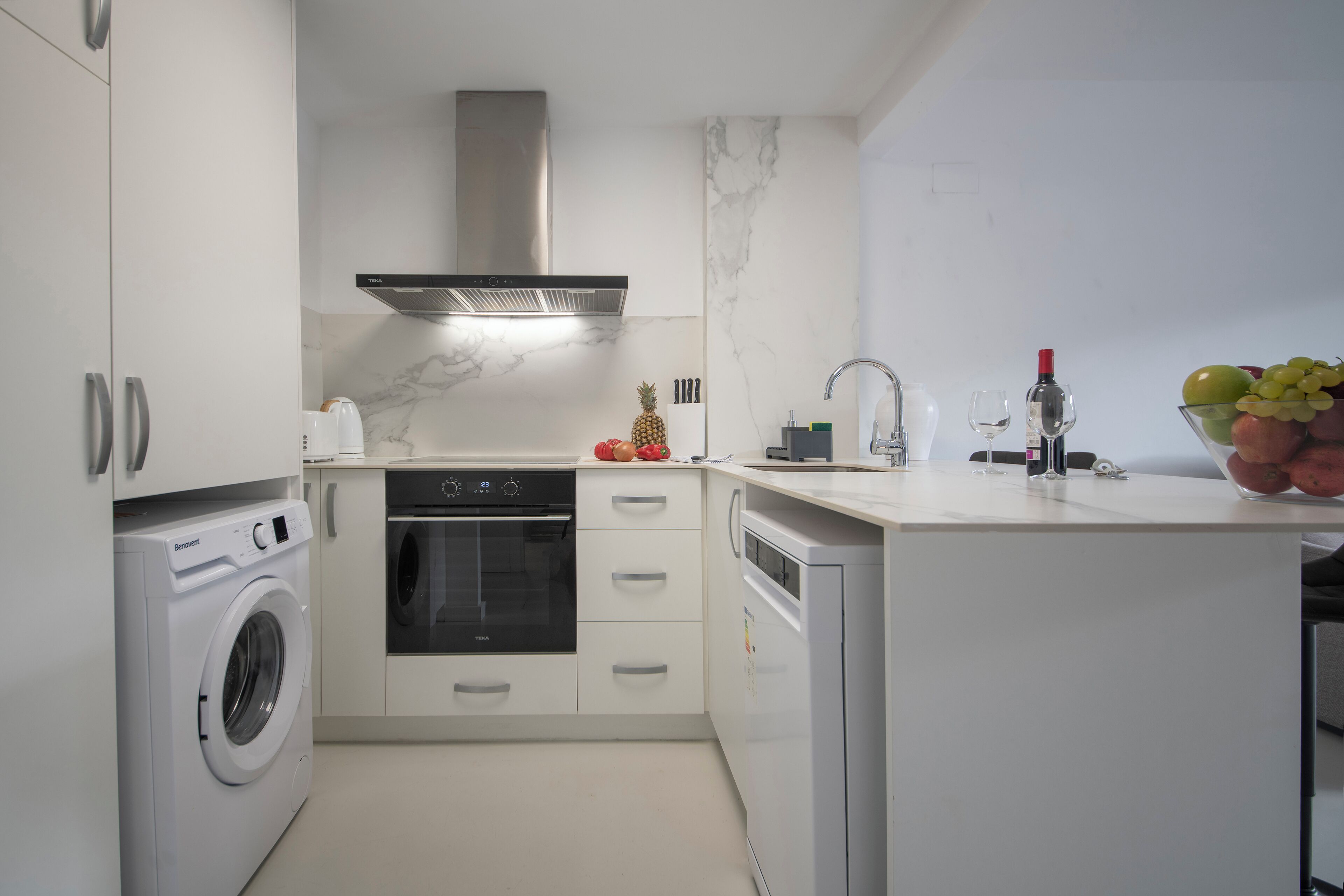 Cocina compacta con lavadora, horno y lavavajillas.