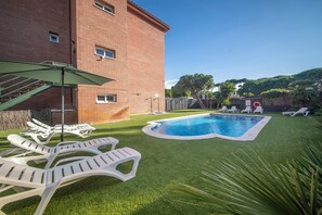 Alberca al aire libre y camastros 