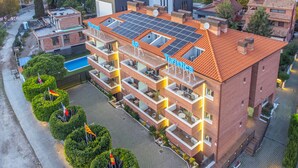 A multi-story hotel with a rooftop solar panel array, balconies, and a swimming pool. - Marsol Apartamentos Turisticos (Castelldefels)