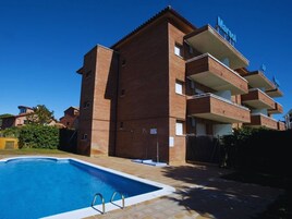 Un edificio de ladrillo de varios pisos con una piscina delantera.