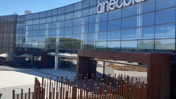A modern building with a glass facade and the name 'Aneblau' displayed prominently. - Marsol Apartamentos Turisticos (Castelldefels)