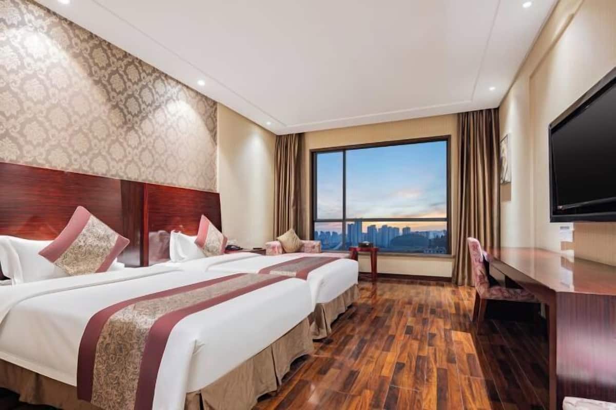 Une chambre d’hôtel avec un grand lit, une télévision et une vue sur le paysage urbain.