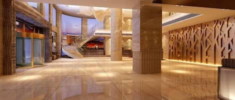 A spacious lobby with a polished floor, a staircase, and a reception desk.