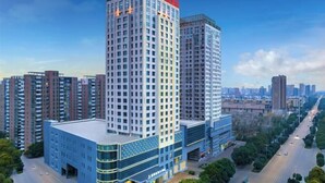 A high-rise hotel with multiple floors, a prominent entrance, and a surrounding urban environment. - Howard Johnson Park Plaza Hotel (Jingshan Railway Station Inn) (Jingshan)