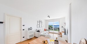 Ein zeitgemäßer Wohnbereich mit Essplatz, einer Couch und Blick ins Freie.