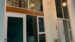 A building with large windows, a decorative wall, and hanging pendant lights. - Super Chic 3bd aptm. sauna/jacuzzi Mamitas Beach (Playa del Carmen)
