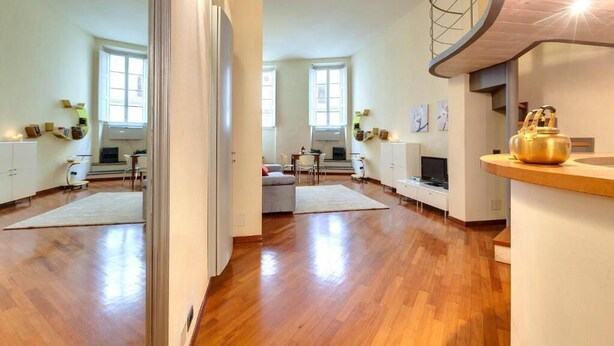 A spacious living area with wooden flooring, a kitchen with a modern design, and a dining area with a table and chairs. - "Ricasoli Premium" open space (Firenze)