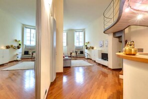 Amplia sala de estar con piso de madera, cocina de diseño moderno y comedor con mesa y sillas.
