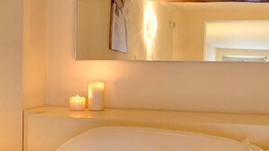 A hotel room with a bed, two lit candles, and a mirror on the wall. - "Ricasoli Premium" open space (Firenze)