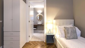 Une chambre à coucher comprenant un lit, une table de chevet, une lampe et une armoire.