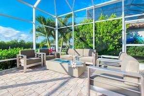 Relax in a stylish lounge area with a clear view of the surrounding greenery and pool.