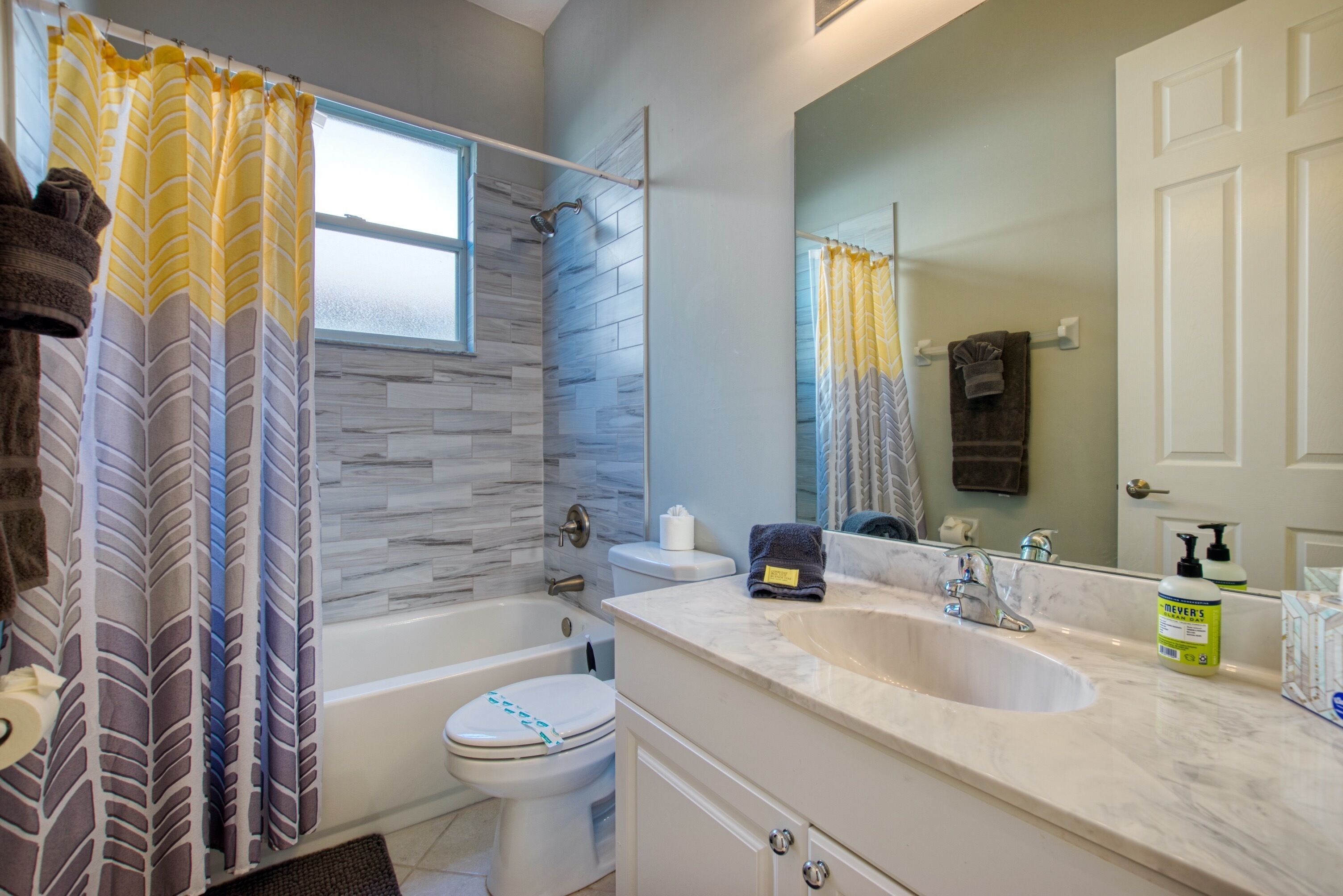 A bathroom with a bathtub, toilet, and sink.