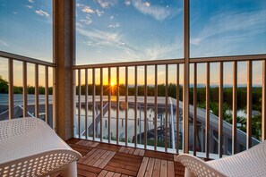Enjoy the serene view of the water and road from this balcony.