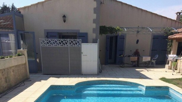 Une piscine rectangulaire à l’eau d’un bleu cristallin, entourée d’une terrasse carrelée.