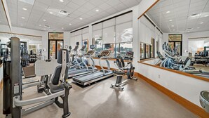 A gym with treadmills, weight machines, and mirrors.