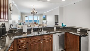 A modern kitchen with granite countertops, wooden cabinets, and stainless steel appliances.