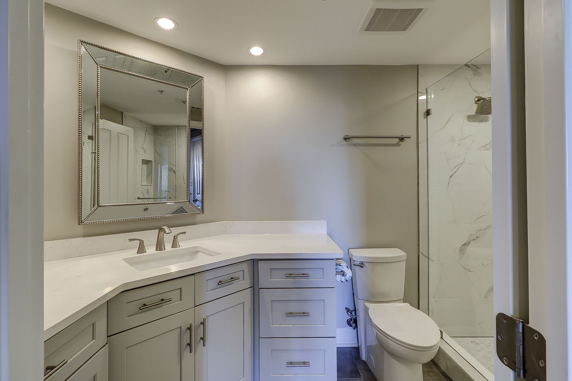 Een moderne badkamer met een grote spiegel, toilet en douche.