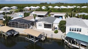 A residential area with houses, a dock, and a body of water. - Saint James hidden gem. 3/2 canal front home with 3 kayaks.  (Saint James City)