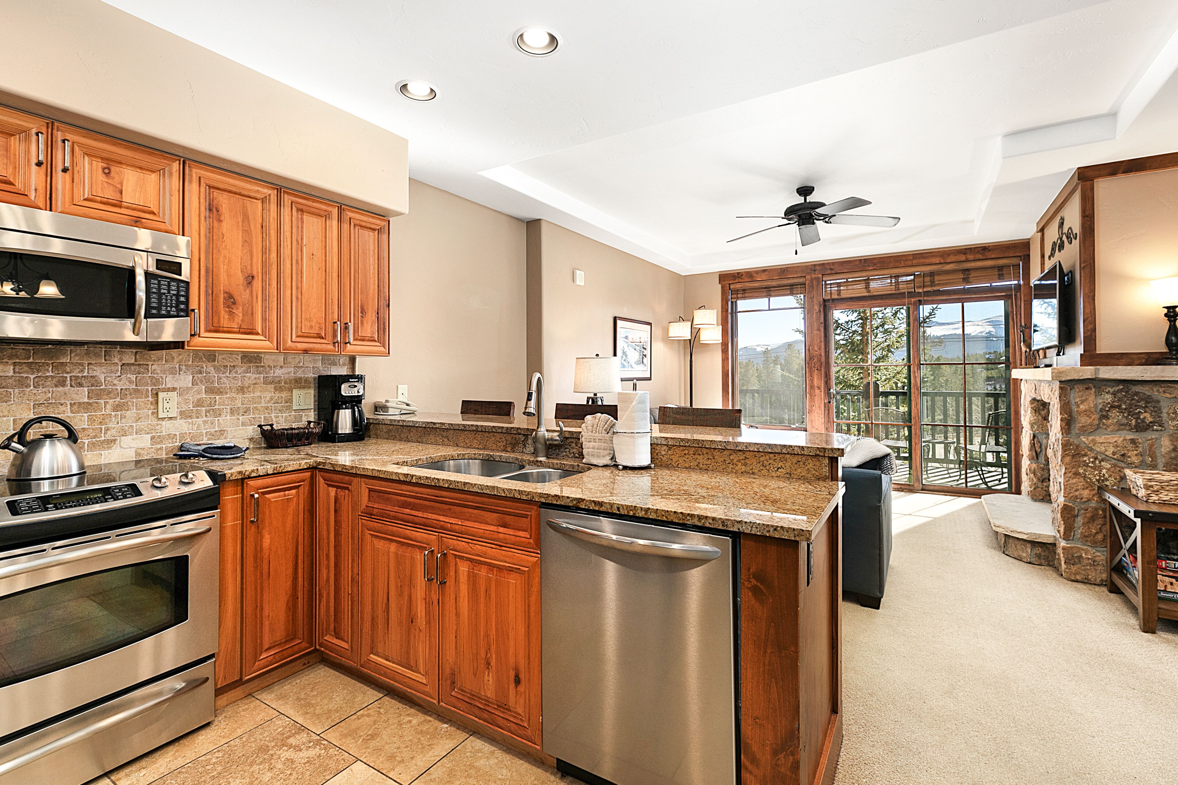 A modern kitchen with wooden cabinets, stainless steel appliances, and a large island.