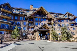 A multi-story hotel with balconies, stone pillars, and a central entrance.
