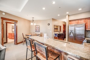 A spacious kitchen with a large island, wooden cabinets, and stainless steel appliances.