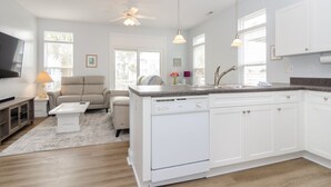 A modern kitchen with white cabinetry, a built-in dishwasher, and pendant lighting. - 3 BR duplex w Rooftop sundeck and ocean views! (Carolina Beach)
