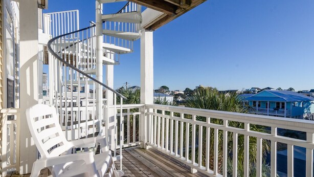 A wooden deck with white railings and a spiral staircase. - 3 BR duplex w Rooftop sundeck and ocean views! (Carolina Beach)