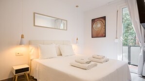 A hotel room with a bed, bedside tables, a window with curtains, and a painting on the wall. - G13 (Barcelona)