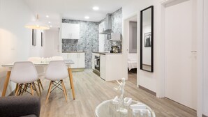 A modern apartment with a dining area, kitchen, and living space. - G13 (Barcelona)