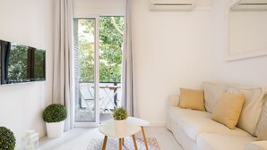 Un salon moderne avec un canapé, une petite table et deux plantes en pot.