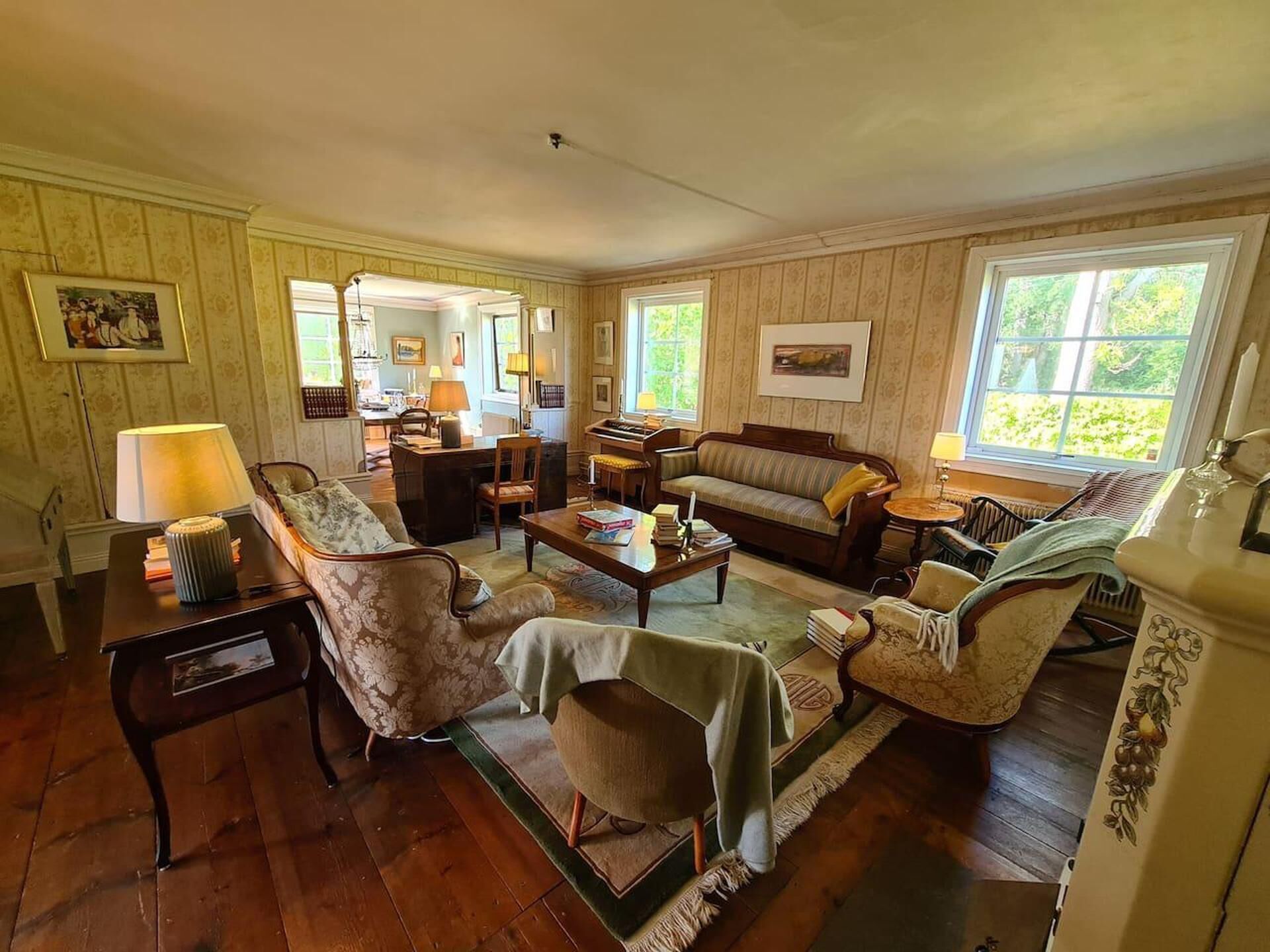 A spacious living room with a sofa, armchairs, a coffee table, and a dining area.
