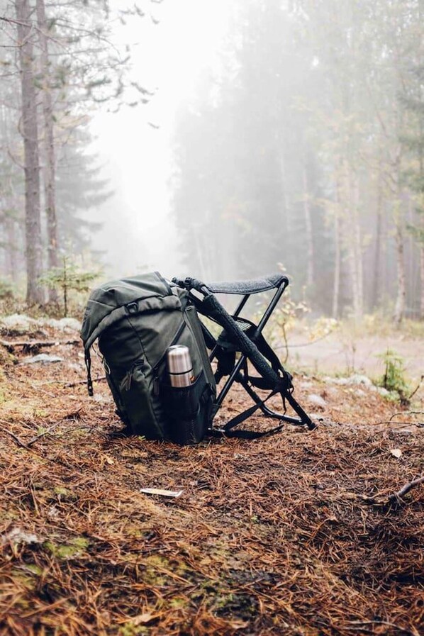 A backpack and a folding chair in a forest. - Charming 6 Bedroom House & Horse Farm - Sleeps 12 (Horndal)