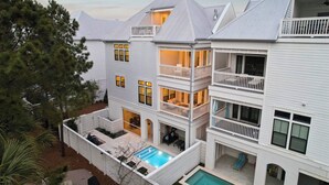 Una casa de diversos pisos amb piscina, balcons i un porxo cobert.