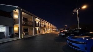 A multi-story motel with a covered parking area. - Kings Inn Motel (Reading)