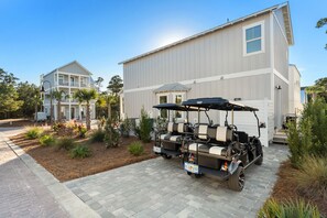 A two-story house with a driveway and a golf cart parked in front.