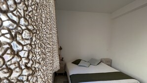 A bedroom with a bed, a nightstand, and two woven baskets. - Appartement en face de la plage *** / Apartment with beach view *** (Sainte-Maxime)