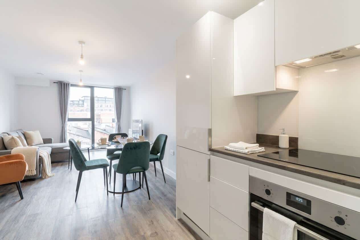 A modern apartment with a dining area, kitchen, and living space.