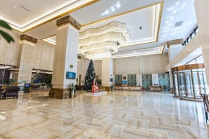 A spacious lobby with a large Christmas tree, marble flooring, and a modern chandelier. - Ruixue International Hotel (Gao'an)