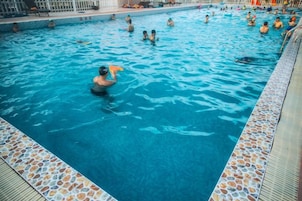 A swimming pool with people in the water.