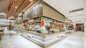 A modern restaurant with a central island serving food, surrounded by seating areas and a clean, polished floor.